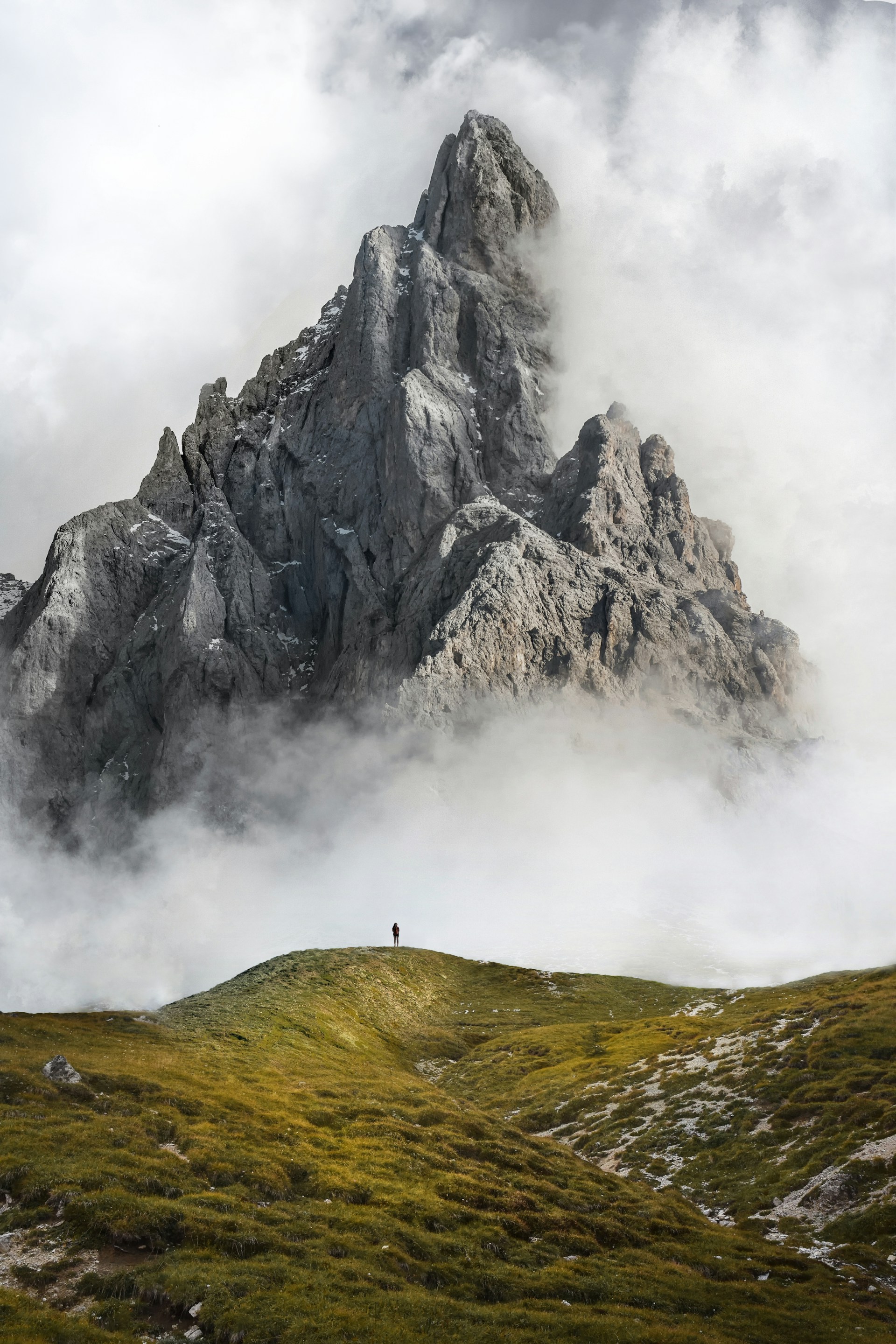 Uomo di fronte a una montagna nebbiosa